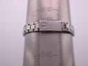 Close-up of the Tissot PR 50 stainless steel bracelet on a wrist sizing gauge, showing a circumference of approximately 16.5cm. The clasp has a signed Tissot 'T'.