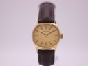 Front view of the gold-toned Tissot 2700 watch with gold dial and brown leather strap.