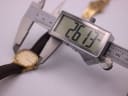 Digital caliper measuring the watch case diameter at 26.13mm.