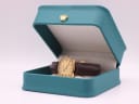 The Tissot watch displayed in a generic green leatherette presentation box.