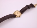 Full watch on brown leather strap, viewed from an angle.