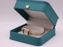 The Gucci 1900L watch resting open in a generic green leatherette display box with a gold crown emblem.