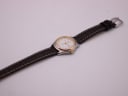 Overhead shot of the Tissot PR 50 watch with its brown leather strap extended flat against a white background.