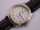 Close-up of the Tissot PR 50's white dial, featuring gold-tone Roman numeral hour markers and hands, with the Tissot logo and date window visible.