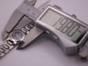 Close-up of a digital caliper measuring the Tissot watch case diameter, displaying 19.88mm.