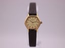 Front view of the Tissot quartz watch with a gold-coloured tonneau case, cream dial, and brown leather strap.