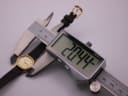 A digital caliper measuring the Tissot watch case, displaying a precise diameter of 20.44mm.
