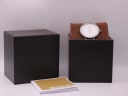 Michael Kors watch displayed with its original dark brown box and accompanying papers, confirming inclusions.