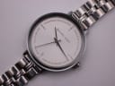 Close-up, slightly angled view of the Michael Kors white dial, showing the crystal minute track and branding.