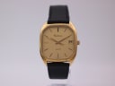Front view of Certina Newport watch with gold cushion case and champagne dial on a display stand.