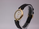 Angled three-quarter view of Raymond Weil 5350 watch on display stand, highlighting the gold case and black leather strap.