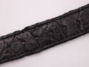 Close-up of the black leather strap's crocodile-effect texture and signs of wear.