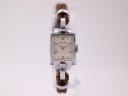 Front view of the Helvetia ladies watch featuring a rectangular silver case, cream dial with Arabic numerals, and a brown woven fabric strap.