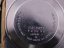 Detailed close-up of the watch's stainless steel case back with engravings for Seiko, serial number, model, and material.