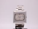 Front view of vintage Seiko 6119-5401 automatic watch with square stainless steel case and cream cushion dial, on stand.