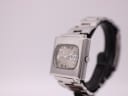 Angled side view of vintage Seiko 6119-5401 showing crown and brushed case finish, on stand.