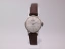 Front view of vintage Seiko 21-0030 ladies' watch with silver sunburst dial and brown leather strap on a watch stand.