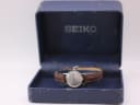 The vintage Seiko watch sitting inside its original, worn blue Seiko presentation box.