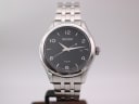 Front view of Seiko V157-0CNO solar watch with black vertically textured dial and stainless steel bracelet.