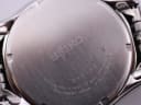 Close-up of the brushed stainless steel case back with Seiko logo, serial number 890144, water resistance, and movement details.