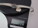 Watch case and case back resting on a digital scale, showing a weight of '22g'.