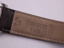 Close-up of the brown leather strap's underside, showing "TISSOT 1853" engraving and "20-18" indicating the lug width.