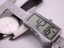Digital caliper measuring the Tissot watch case, showing a precise diameter of 42.16mm.