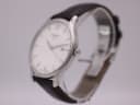 Three-quarter side view of the Tissot T063610 A watch on a display stand, highlighting the polished stainless steel case and crown.
