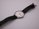 Full overhead view of the Tissot T063610 A watch with its brown leather strap extended on a white surface.