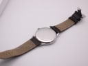 Rear view of the watch, showing the stainless steel case back with engravings, and the extended brown leather strap.