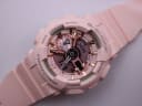 Close-up, angled view of the pink G-SHOCK watch dial, focusing on the ana-digi display and rose gold details.