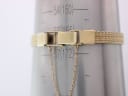Close-up of the gold-tone mesh bracelet clasp on a wrist sizing gauge, showing a measurement around 172mm.