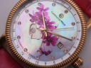 Extreme close-up of the Constantin Weisz dial, bringing out the iridescent lustre of the mother-of-pearl, the individual crystal hour markers, the delicate pink flower motif, and the exposed gears of the open-heart mechanism.