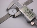Digital caliper measuring the watch case diameter, displaying an exact measurement of 32.91mm, with the watch visible in the background.