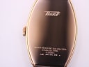 Close-up of the polished rose gold PVD case back, showing Tissot model number, serial, and water resistance engraving.