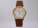 Front view of gold-tone Timex octagonal quartz watch with cream dial and brown leather strap.