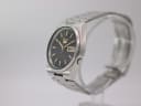 Angled side view of the Seiko watch, showing the cushion case and stainless steel bracelet.