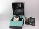 The Giorgio Armani watch displayed in its original 'Whatever It Takes' presentation box with accompanying papers.