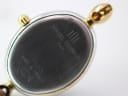 Detailed view of the watch case back, showing 'Michel Herbelin Paris' and '7003 Made In France' engravings with surface scratches.