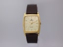 Front view of the Lorus Y131-5260 quartz watch, showing its rectangular gold-tone case, cream dial with baton indices, and brown leather strap on a watch stand.