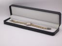 The Bulova two-tone watch displayed open in a generic black presentation box.