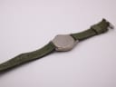 Reverse full length view of Lorus watch with green fabric strap, showing case back details.