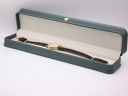 The Tissot watch resting inside a generic green leatherette presentation display box.