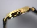 Detailed side view of the gold-toned watch case and the signed Tissot crown with its distinctive 'T' logo.