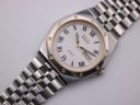 Overhead flat lay shot of the Seiko SQ 100 two-tone watch with its steel bracelet extended.