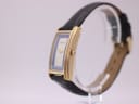 Side profile view of the Gucci 2600 M watch, showcasing the curved gold-tone case and textured crown.