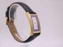 Angled side profile view of the Gucci 2600 M watch, highlighting the case curve and the black leather strap.