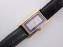 Top-down view of the rectangular gold-tone Gucci watch with its distinctive blue and white dial and black leather strap.