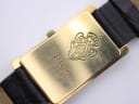 Close-up of the gold-tone case back of the Gucci 2600 M, showing engraved model number, serial number, and the Gucci crest logo.