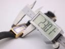 Digital caliper measuring the width of the Gucci watch case, displaying a precise measurement of 23.01 mm.